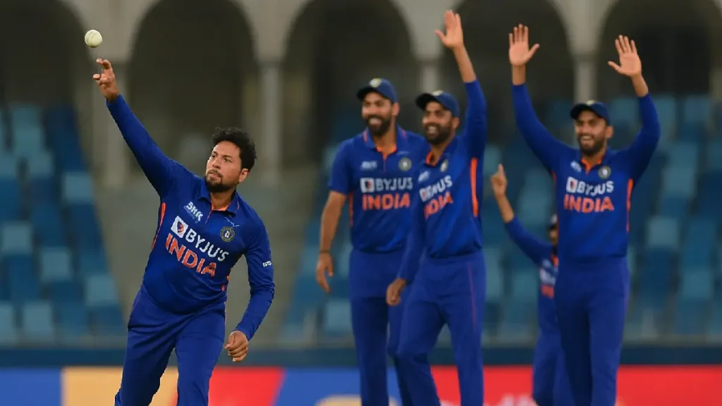 Indian cricketer Kuldeep Yadav bowling as teammates celebrate during UAE vs India match in Dubai.